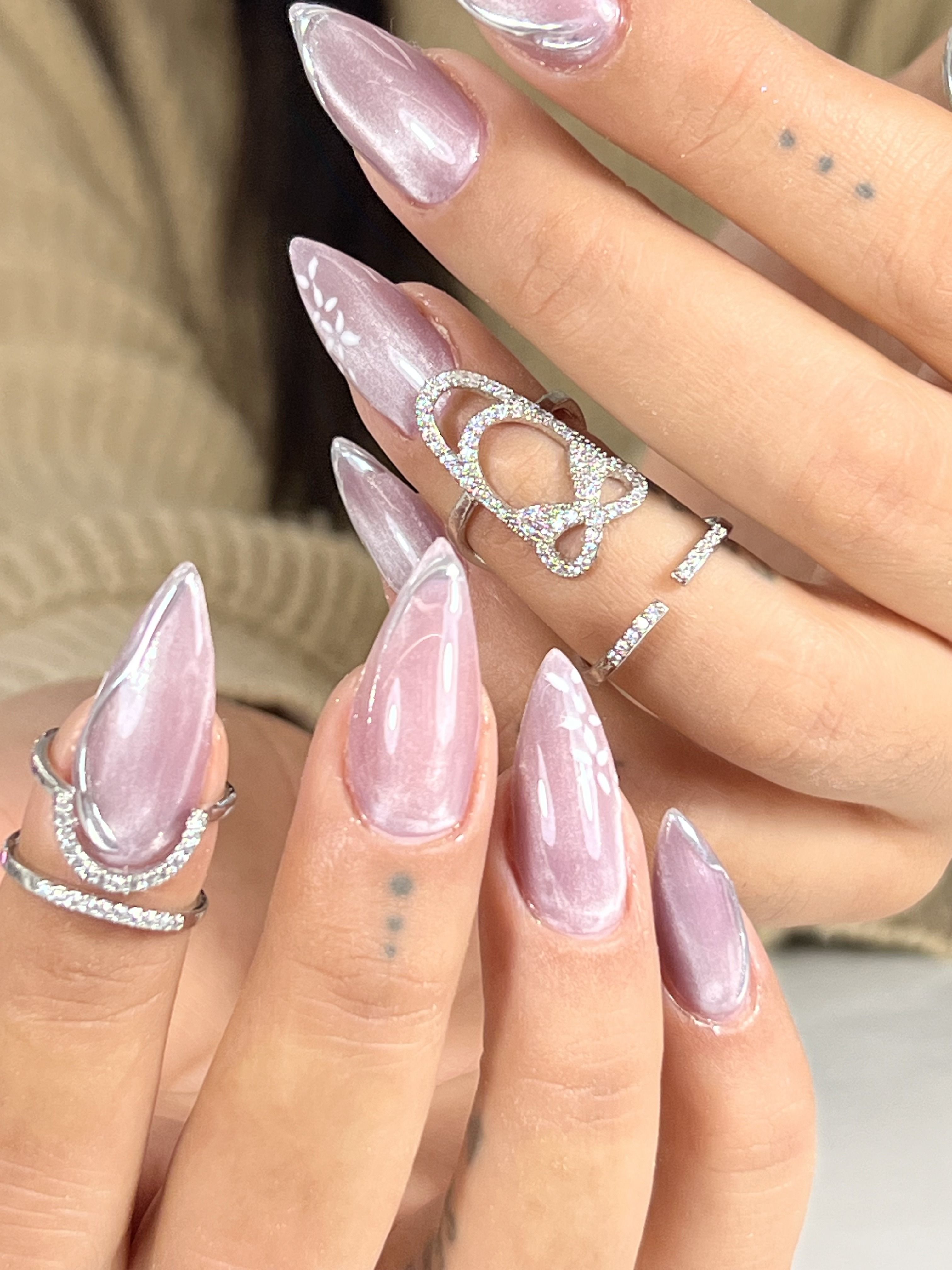 Uñas stiletto en rosa cromado con dibujo blanco